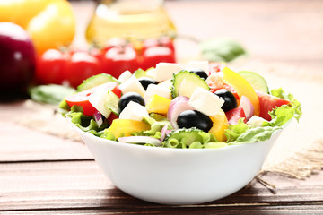 Vegetable salad in bowl on brown wooden table