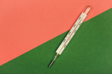 Medical mercury thermometer, Living Coral, trendy color 2019 background.  Free space for text.