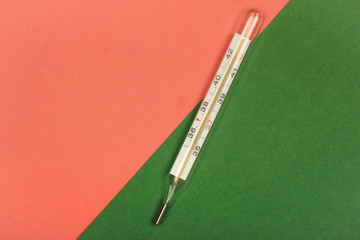 Medical mercury thermometer, Living Coral, trendy color 2019 background.  Free space for text.
