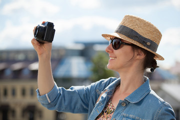 Happy smiling young tourist girl taking photo