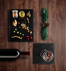 Mulled wine recipe ingredients and kitchen accessories, bottle of red wine, cinnamon, anise stars, orange, brown sugarand spice on rustic wood background.