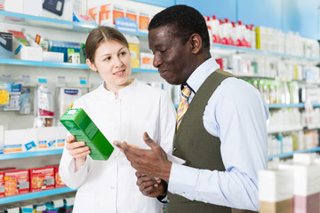 druggist explaining prescribed medicine to man