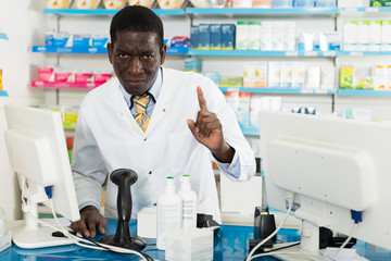 male pharmacist drawing attention of clients