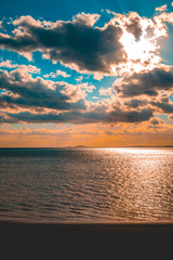 darken beach in the afternoon sun with big clouds in the sky