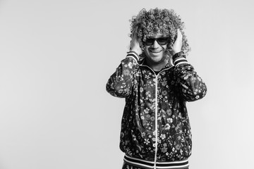 Adult shylish funky man in fashion clothes, posing on white studio background. Excited bizarre crazy shocked male shouting, tearing hair. Surprised funny happy young brazilian guy screaming.