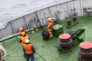 seamen carry out a rescue operation on the deck of a ship