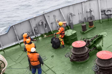 Muurstickers seamen carry out a rescue operation on the deck of a ship © Uladzimir