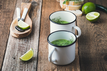 Green pea soup in rural mug with sprouts on top
