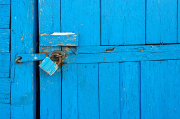 Rusty padlock on old wooden door