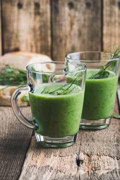 Green pea soup in glass mug with sprouts on top