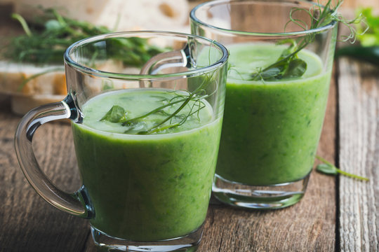 Green pea soup in glass mug with sprouts on top