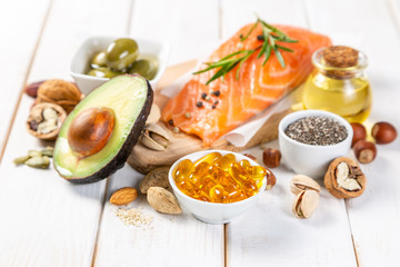 Selection of healthy unsaturated fats, omega 3 - fish, avocado, olives, nuts and seeds