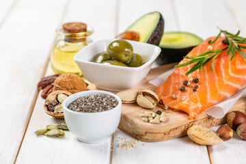 Selection of healthy unsaturated fats, omega 3 - fish, avocado, olives, nuts and seeds - obrazy, fototapety, plakaty