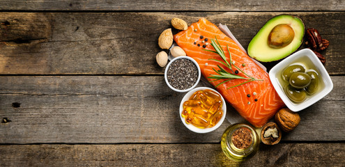 Selection of healthy unsaturated fats, omega 3 - fish, avocado, olives, nuts and seeds