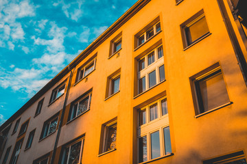 Fototapeta na wymiar orange apartment building with blue fluffy sky
