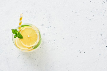 Ice cold summer drink. Traditional lemonade or mojito with lemon, mint and ice on white background....