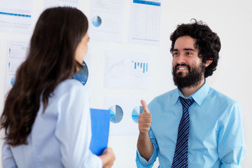 Fototapeta premium Turkish businessman giving congratulations to successful businesswoman
