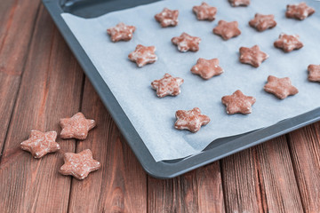 Star shaped ginger cookies on baking tray.