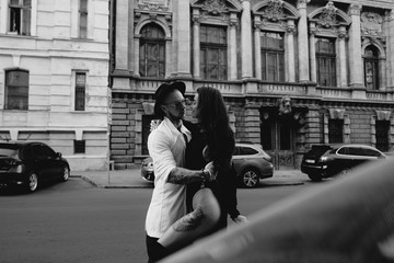 A young, sexy couple of lovers pose for a camera on the streets