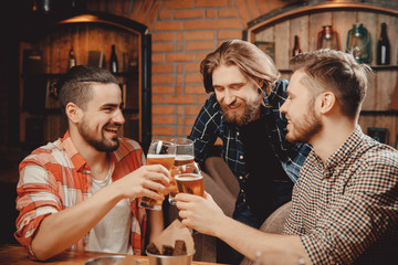 Meet cheerful friends at bar, drink draft beer in mugs and chat