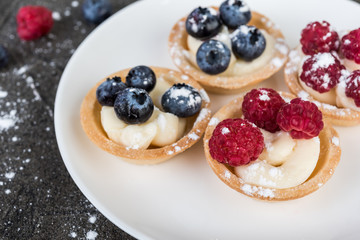 tartlets or cake with cream and  berries. Pastry dessert.