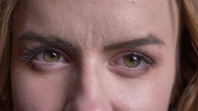 Closeup portrait of adult caucasian female face with green eyes looking straight at camera with neutral facial expression