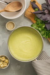 Healthy homemade fresh broccoli cream soup in cooking pan on grey background. top view. vertical