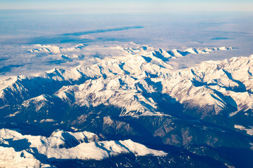 Swiss, Italy and Austrian Alps with snowy mountain tops aerial view towards the east during afternoon flight