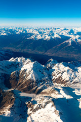 Swiss, Italy and Austrian Alps with snowy mountain tops aerial view towards the east during afternoon flight