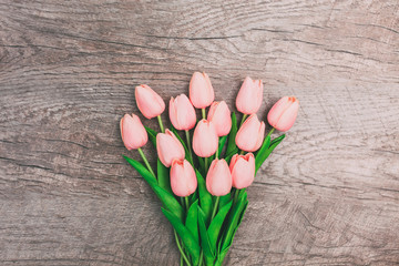 Bouquet of pink tulips on wooden background