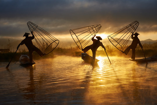 Silhouettes of three fishermen on Inle lake Myanmar