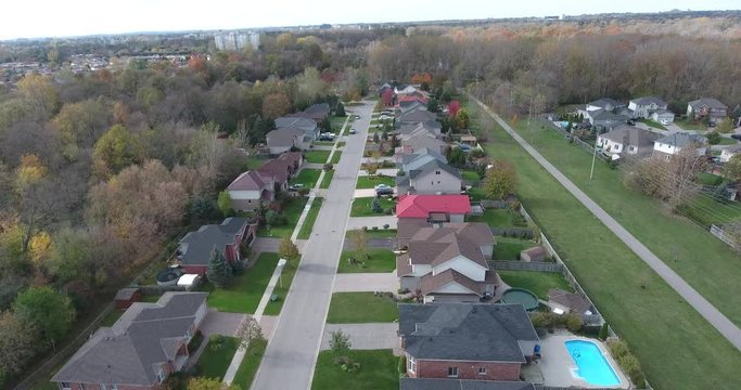 Flying Over Houses Near Power Lines And Autumn Forest With Bare Trees And City In Distance 4K