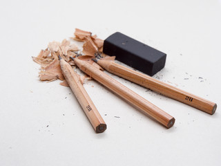 Pencils and black eraser, debris on grey sketch notepad background