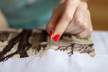 woman working on cross-stitch embroidery