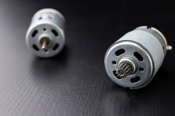 Small electric engine on a wooden dark table. Electric drive for small home appliances.