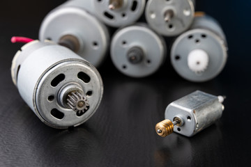 Small electric engine on a wooden dark table. Electric drive for small home appliances.