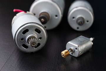 Small electric engine on a wooden dark table. Electric drive for small home appliances.