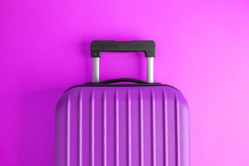 Luggage on purple background minimalistic vacation concept.