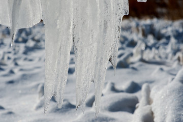  Closeup of icicles covering security fence on a sunny winter day.