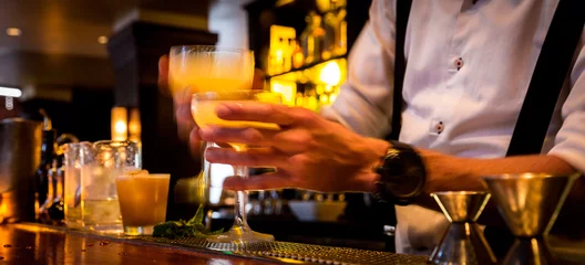 Poster Barman met cocktails in een drukke bar met bewegingsonscherpte. Barman die drankjes aan de server overhandigt met bewegingsonscherpte. © Crin