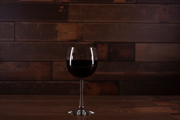 Glass of red wine with dark wood background