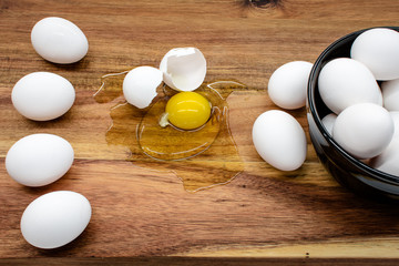 Black bowl with white eggs standing on the wooden table