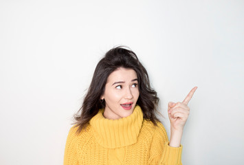 Young beautiful woman over isolated background amazed and smiling while presenting with hand and pointing with finger.