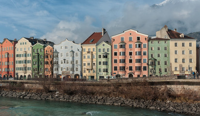 INNSBRUCK, AUSTRIA - JANUARY, 01 2019: Panoramic view of the historic city center of Innsbruck with colorful houses along Inn river and famous Austrian mountain in the background - Tyrol, Austria