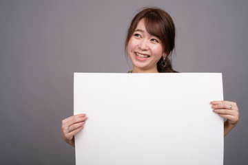 Fototapeta premium Asian woman holding empty white board with copyspace