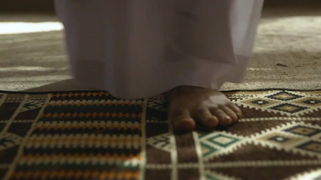 Man Removing Flip Flop Sandles By Rug