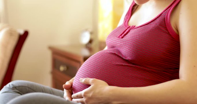 Closeup of pregnant woman in bed