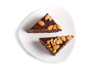 Chocolate cake with caramel, peanuts and almonds isolated on a white background.