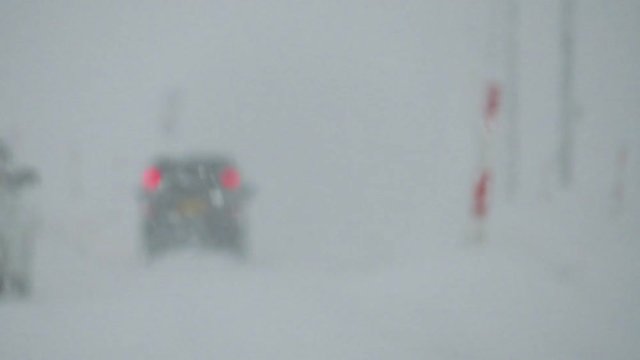 大雪が降る中を走行する自動車　冬　交通　イメージ