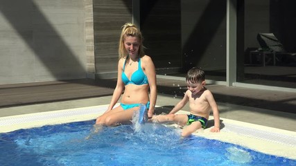 Cute baby boy enjoying with his mother in the swimming pool